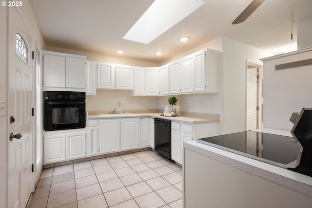 kitchen with light tile patterned floors, white cabinetry, black appliances, and a sink