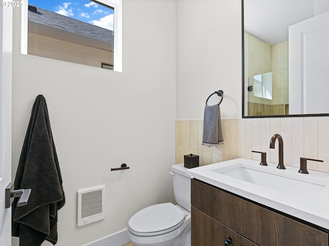 full bath featuring heating unit, toilet, tile walls, walk in shower, and vanity