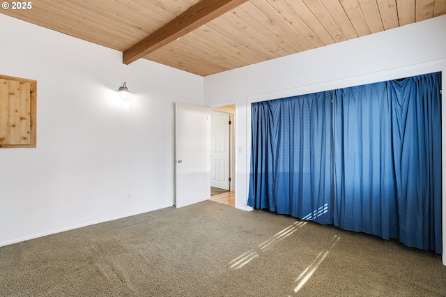 empty room featuring beamed ceiling, carpet flooring, and wood ceiling