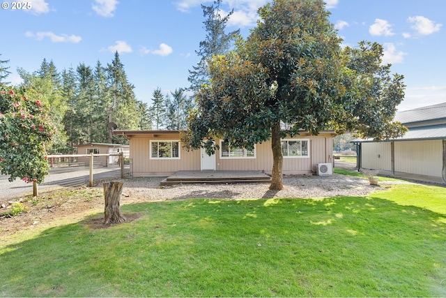 rear view of house with ac unit, a wooden deck, a lawn, and fence