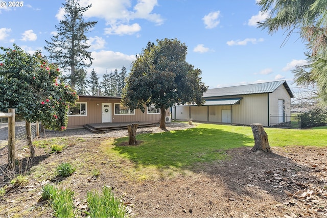 rear view of house featuring a yard and fence