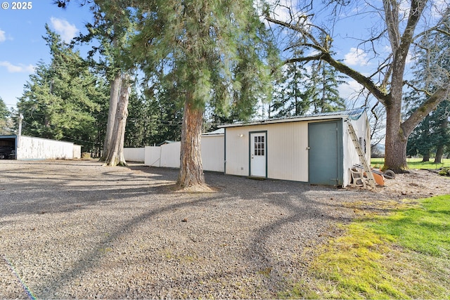 view of outdoor structure featuring an outbuilding and fence