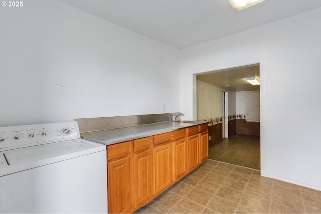 washroom with a sink, washer / clothes dryer, and cabinet space