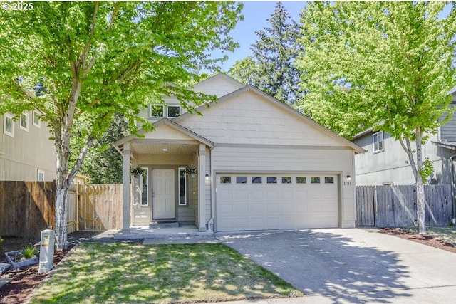 view of front facade with concrete driveway, an attached garage, and fence