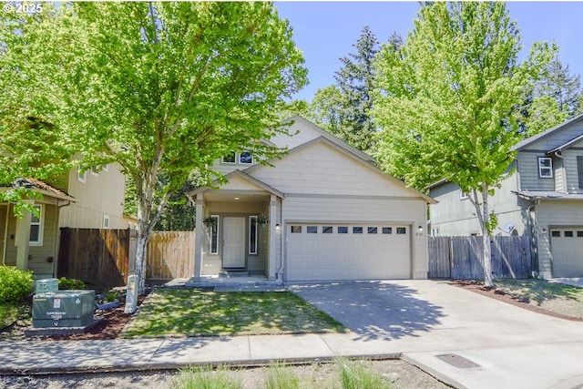 view of front of house featuring driveway, a garage, and fence