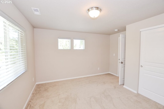 unfurnished bedroom with light colored carpet, baseboards, and a closet