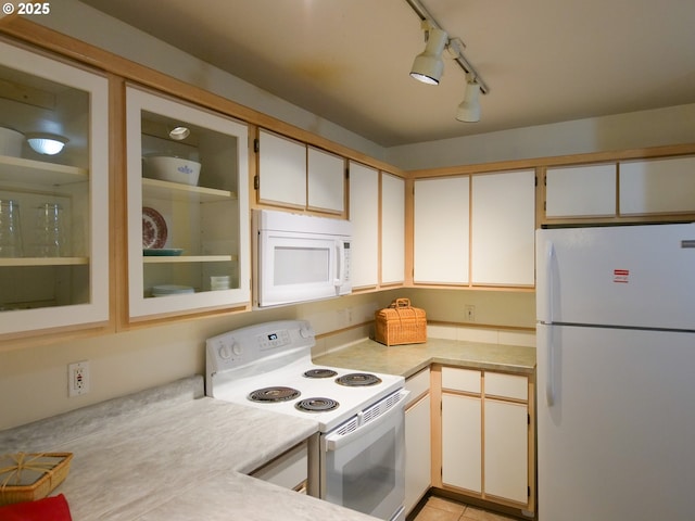 kitchen with glass insert cabinets, white appliances, light tile patterned flooring, and light countertops