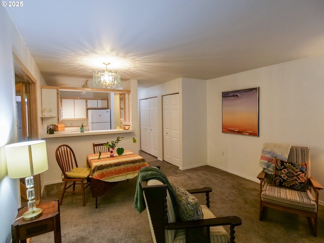 living area with a chandelier, dark carpet, and baseboards