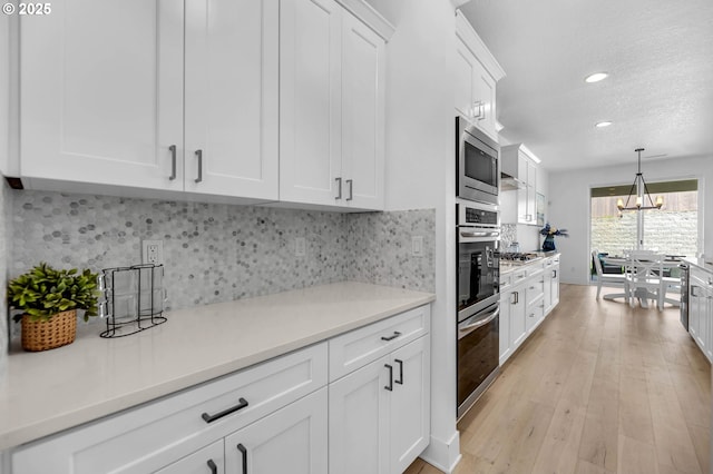 2928 S Harper Valley Way, Ridgefield, WA 98642 - kitchen featuring tasteful backsplash, light countertops, white cabinetry, recessed lighting, and stainless steel appliances