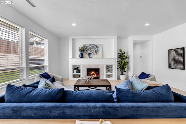 2928 S Harper Valley Way, Ridgefield, WA 98642 - living room featuring visible vents, baseboards, a stone fireplace, and recessed lighting