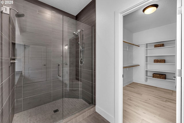 2928 S Harper Valley Way, Ridgefield, WA 98642 - bathroom with a stall shower, wood finished floors, baseboards, and a walk in closet