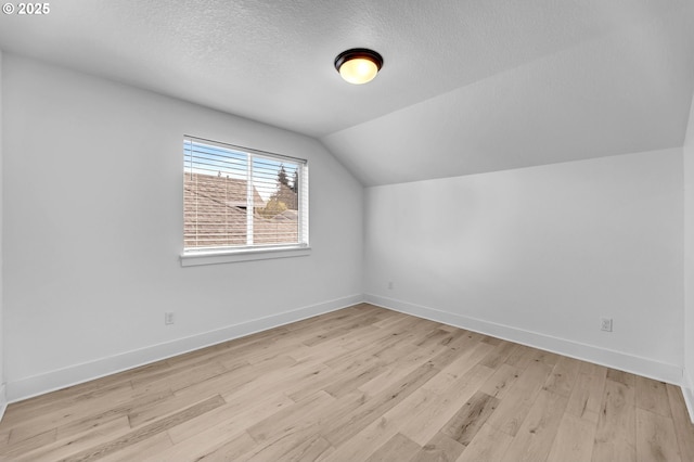 2928 S Harper Valley Way, Ridgefield, WA 98642 - additional living space featuring a textured ceiling, light wood-type flooring, baseboards, and lofted ceiling