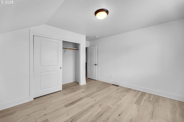 2928 S Harper Valley Way, Ridgefield, WA 98642 - unfurnished bedroom with light wood-type flooring, a closet, visible vents, lofted ceiling, and baseboards