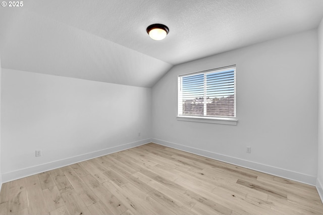 2928 S Harper Valley Way, Ridgefield, WA 98642 - additional living space with light wood finished floors, baseboards, vaulted ceiling, and a textured ceiling