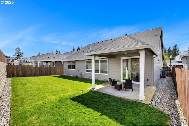 2928 S Harper Valley Way, Ridgefield, WA 98642 - back of property featuring a shingled roof, a fenced backyard, a patio area, and a lawn