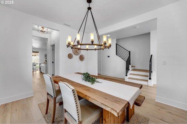 2928 S Harper Valley Way, Ridgefield, WA 98642 - dining space with light wood-style flooring, an inviting chandelier, visible vents, and stairway