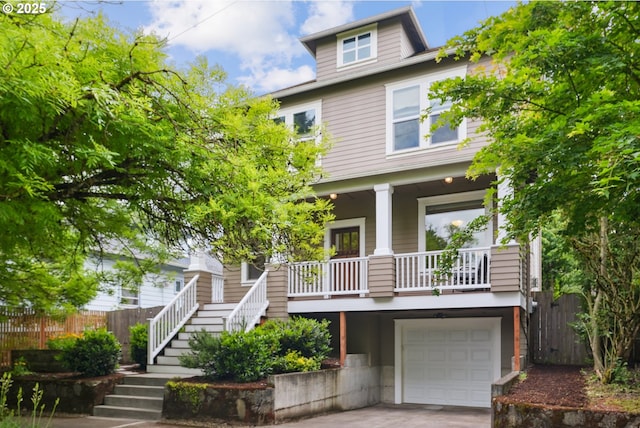 american foursquare style home with stairs, a porch, fence, a garage, and concrete driveway