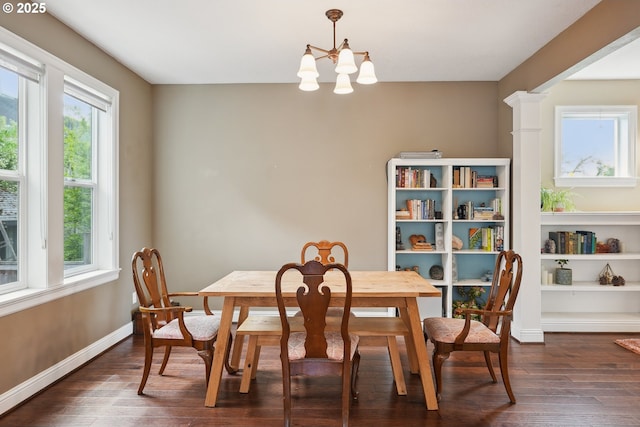 dining space featuring dark wood finished floors, a chandelier, and baseboards