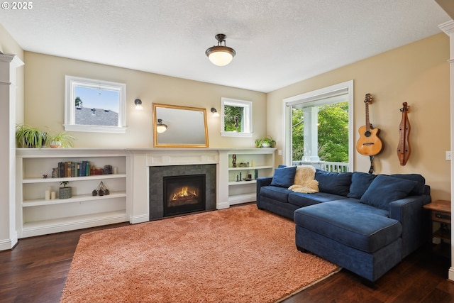 living room featuring dark wood finished floors, a fireplace, and a textured ceiling