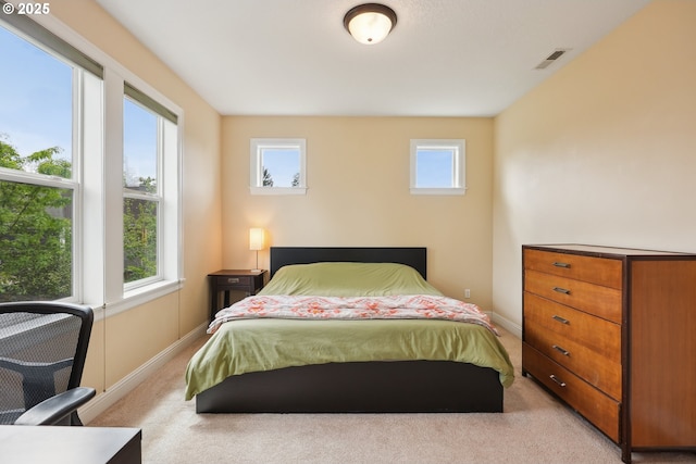 bedroom with light colored carpet and baseboards