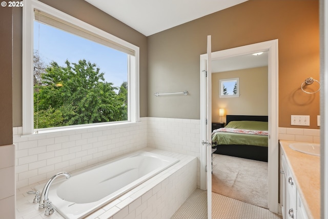 bathroom featuring a bath, ensuite bathroom, and vanity