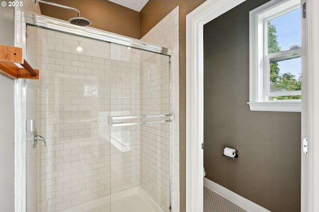 full bathroom with a stall shower and baseboards