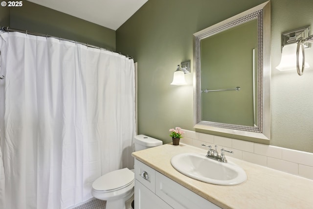 bathroom featuring toilet, vanity, and curtained shower