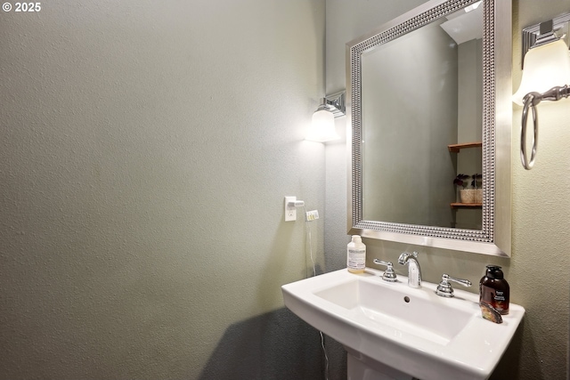 bathroom featuring a sink and a textured wall
