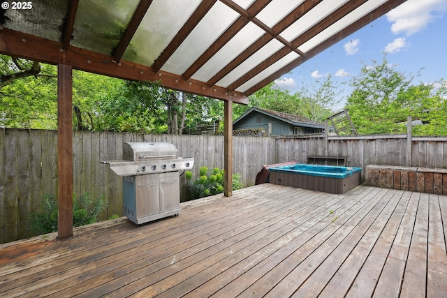 wooden terrace featuring a hot tub, a fenced backyard, and a grill