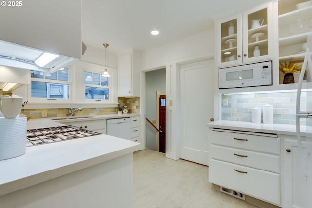 kitchen featuring white cabinetry, white appliances, light countertops, and a sink