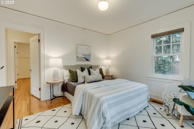 bedroom with light wood-style flooring and baseboards