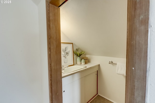 bathroom with vanity and lofted ceiling