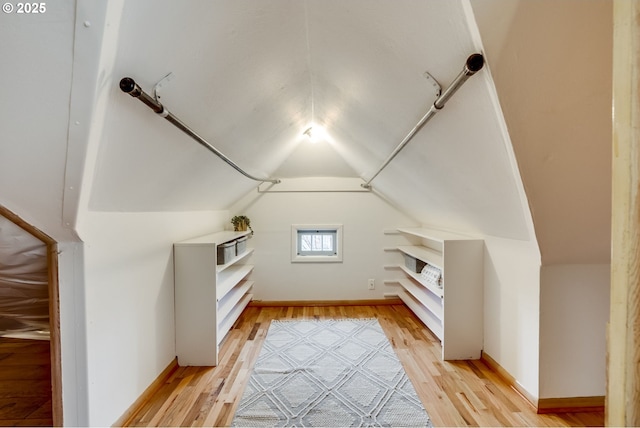 bonus room featuring vaulted ceiling, light wood-style flooring, and baseboards