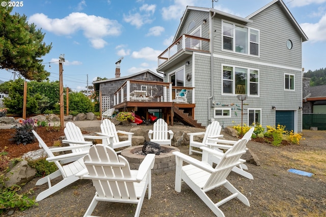 4330 Mcminnville Ave, Neskowin, OR 97149 - rear view of house featuring stairway, a fire pit, a wooden deck, a balcony, and an attached garage