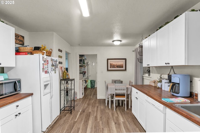 3911 E 16th Ave, Eugene, OR 97403 - kitchen featuring wooden counters, white appliances, light wood-type flooring, white cabinetry, and a textured ceiling