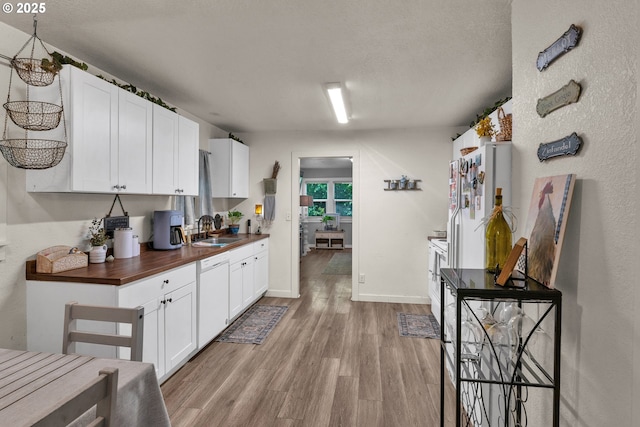3911 E 16th Ave, Eugene, OR 97403 - kitchen featuring white dishwasher, light wood-type flooring, white cabinetry, butcher block counters, and a textured ceiling