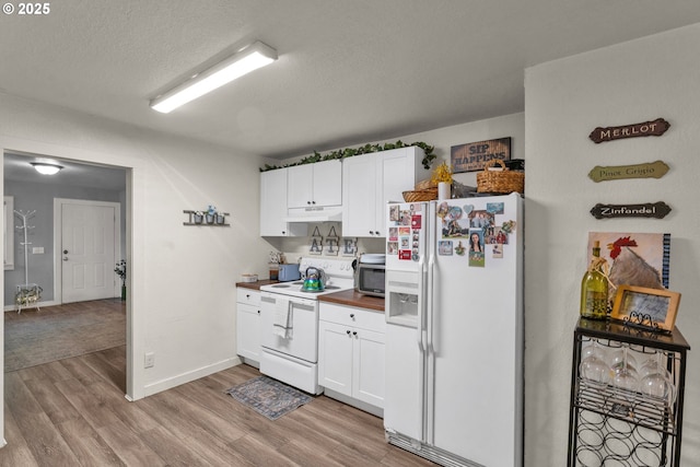 3911 E 16th Ave, Eugene, OR 97403 - kitchen featuring white appliances, light wood-style flooring, white cabinets, under cabinet range hood, and a textured ceiling
