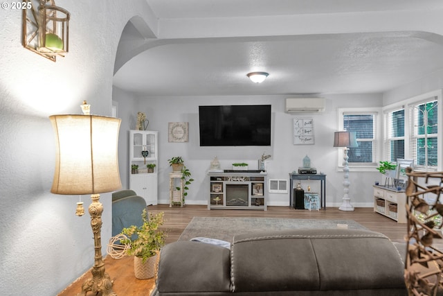 3911 E 16th Ave, Eugene, OR 97403 - living room featuring a wall mounted AC, wood finished floors, and arched walkways