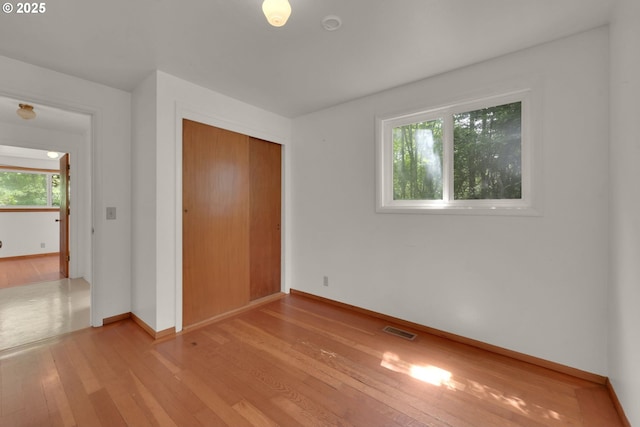 78650 Rat Creek Rd, Cottage Grove, OR 97424 - unfurnished bedroom with light wood finished floors, multiple windows, baseboards, and a closet