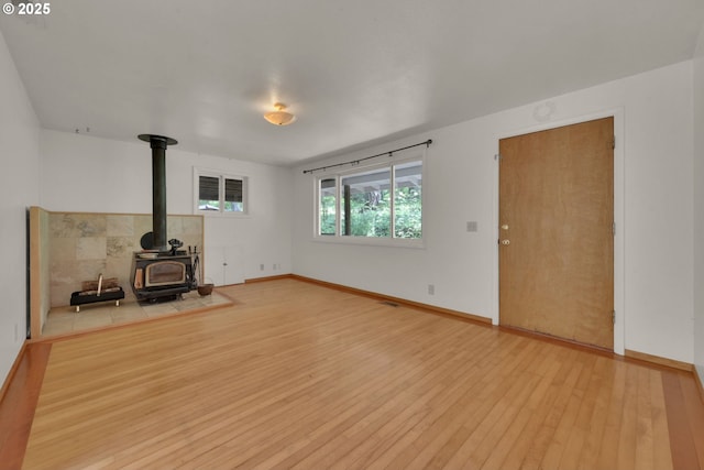 78650 Rat Creek Rd, Cottage Grove, OR 97424 - unfurnished living room with a wood stove, light wood-style flooring, and baseboards