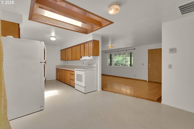 78650 Rat Creek Rd, Cottage Grove, OR 97424 - kitchen featuring white appliances, light countertops, baseboards, brown cabinetry, and under cabinet range hood