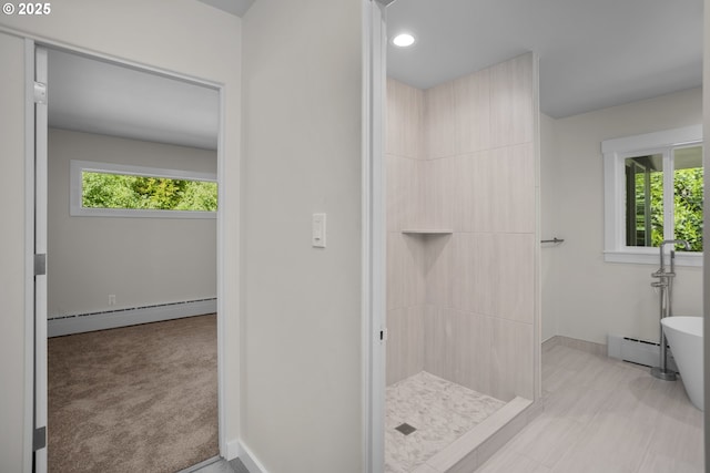 bathroom with baseboards, tiled shower, baseboard heating, and a freestanding bath