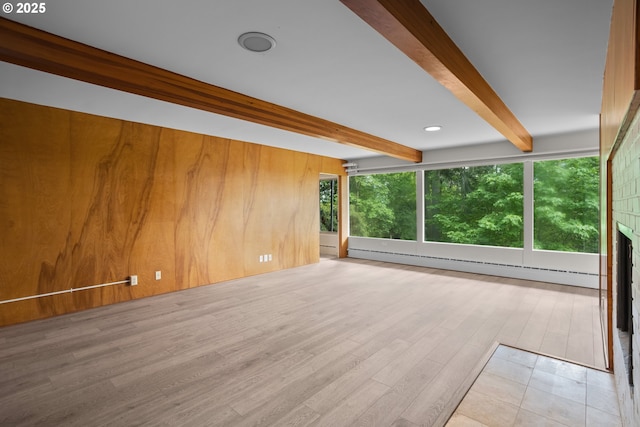 unfurnished living room with a baseboard radiator, wood walls, wood finished floors, beamed ceiling, and a large fireplace