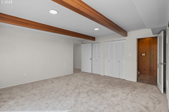 unfurnished bedroom with carpet flooring, beamed ceiling, multiple closets, and recessed lighting