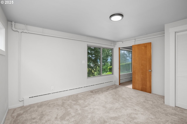 unfurnished bedroom with a baseboard heating unit, carpet flooring, and a closet