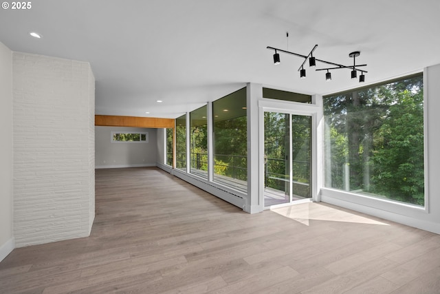 bonus room featuring baseboards, plenty of natural light, and wood finished floors