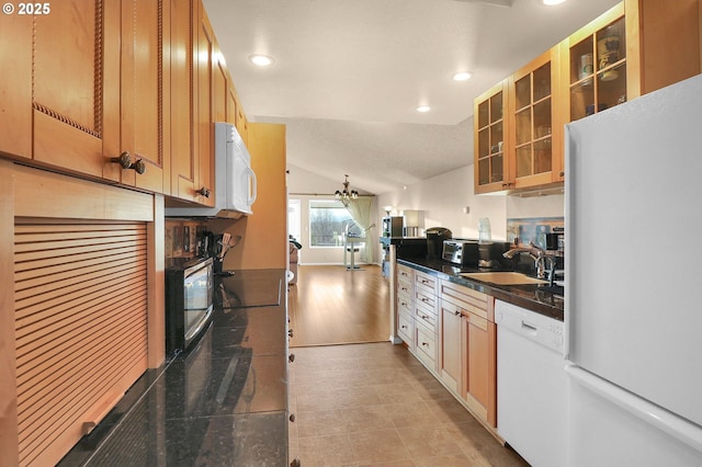 kitchen featuring dark countertops, a sink, lofted ceiling, recessed lighting, and white appliances
