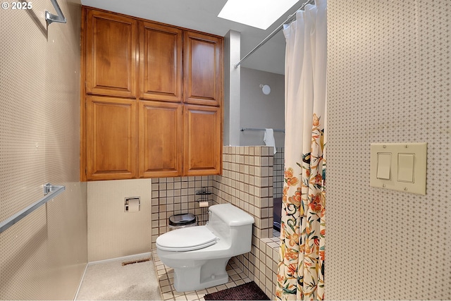 full bath featuring toilet, tile patterned floors, and curtained shower