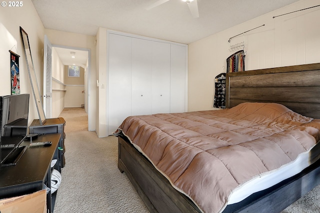 bedroom featuring ceiling fan, light carpet, and a closet