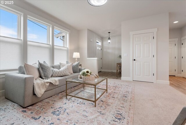 living room featuring recessed lighting, baseboards, and carpet flooring
